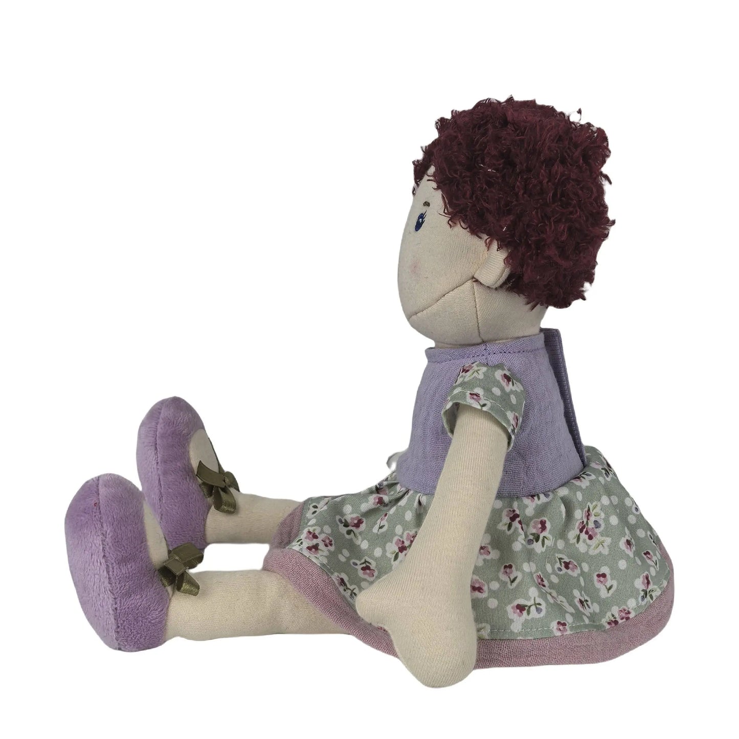 Textile doll with purple dress and floral skirt on a white background