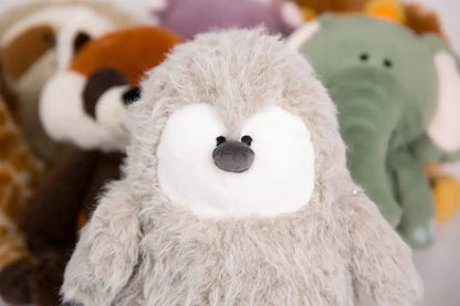 Close-up of a plush penguin chick toy with a blurred background of other toys