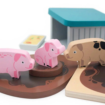 Wooden pig sty set with three pigs on a brown platform, one of which is pink.