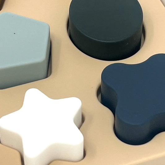 Close-up of a shape sorter toy with various geometric shapes.