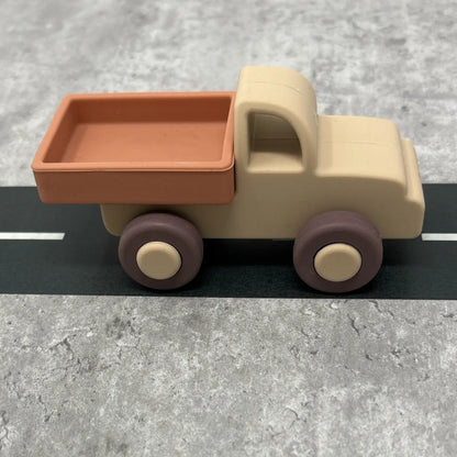 Toy truck with a brown bed and beige body on a grey surface