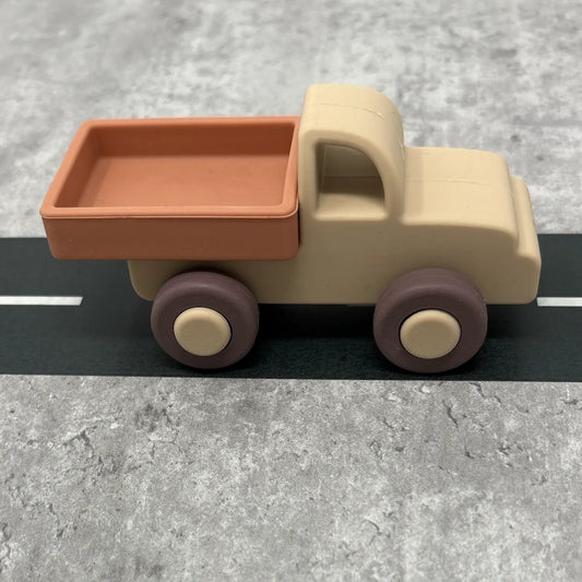 Toy truck with a brown bed and beige body on a grey surface