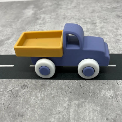 Toy truck with blue body and yellow bed on a grey surface
