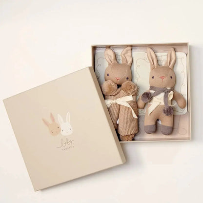 Two knitted rabbit toys in a gift box with a visible brand logo on a light background.