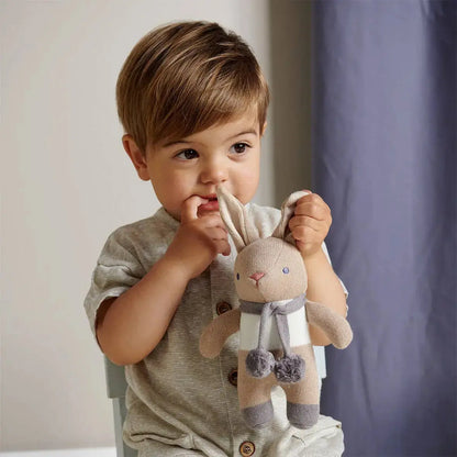 Child holding a plush toy in a neutral setting