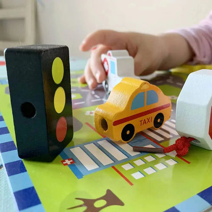 Child playing with toy cars and traffic light on a colourful play mat